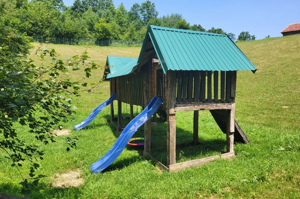Djeca se igraju na toboganu u prirodnoj dječijoj igraonici Etno kompleksa Brkić
